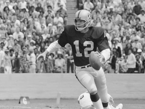 Oakland Raider quarterback Ken Stabler sprints away from lunging Pittsburgh Steeler defensive tackle Steve Furness during second quarter action August 17, 1975 in Berkeley Calif.